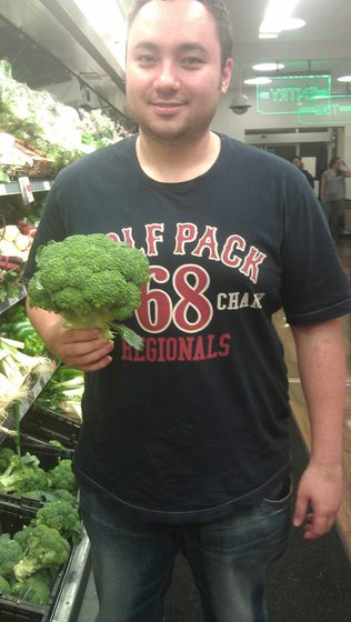 Before: holding a head of broccoli at the supermarket
