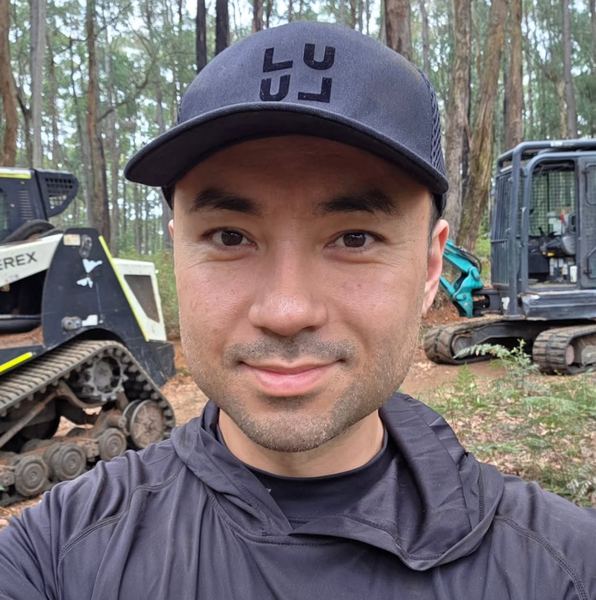 Now: in a cap, smiling in the forest